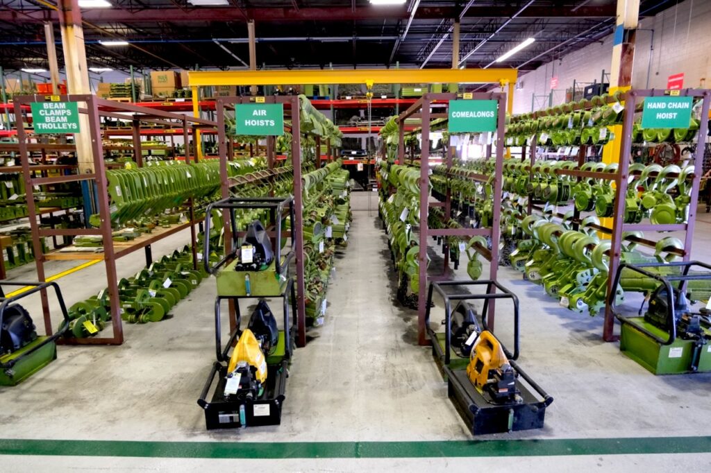 Photo of an LGH warehouse with shelving units containing lifting hoist rentals.