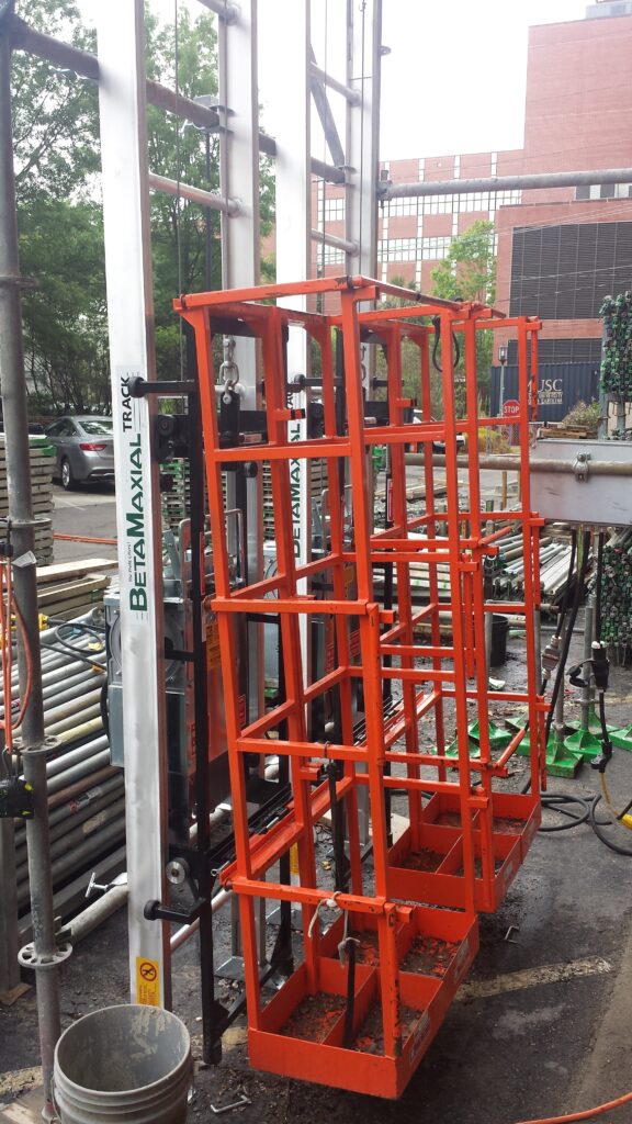 The Beta Max Maxial Track Hoist, an electric scaffolding hoist system rental from LGH, on a jobsite.