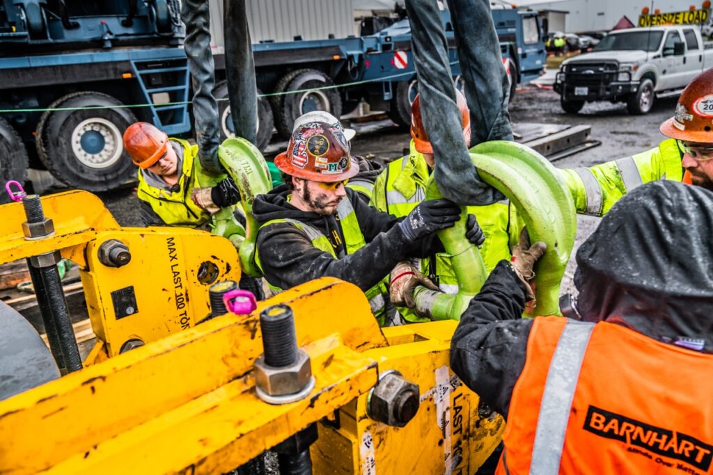 Construction workers attaching a large polyester round rigging sling to a shackle from LGH.