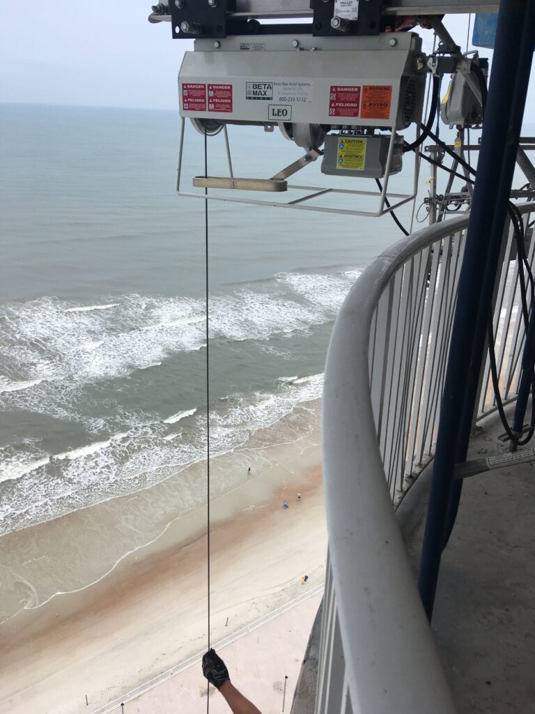 A Beta Max electric cable hoist rental from LGH, being used on a jobsite with the ocean in the background.