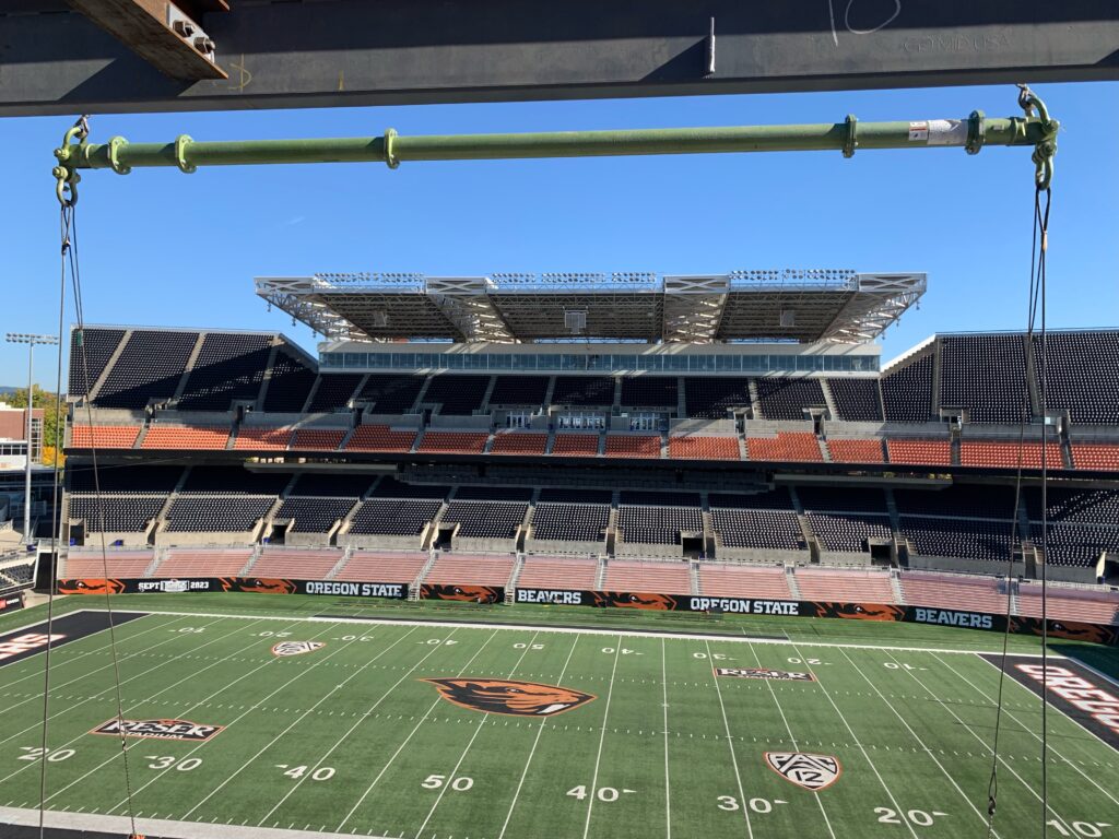 A jobsite photo of a modular spreader bar with shackles and wire rope slings from LGH, inside a football stadium in Oregon.