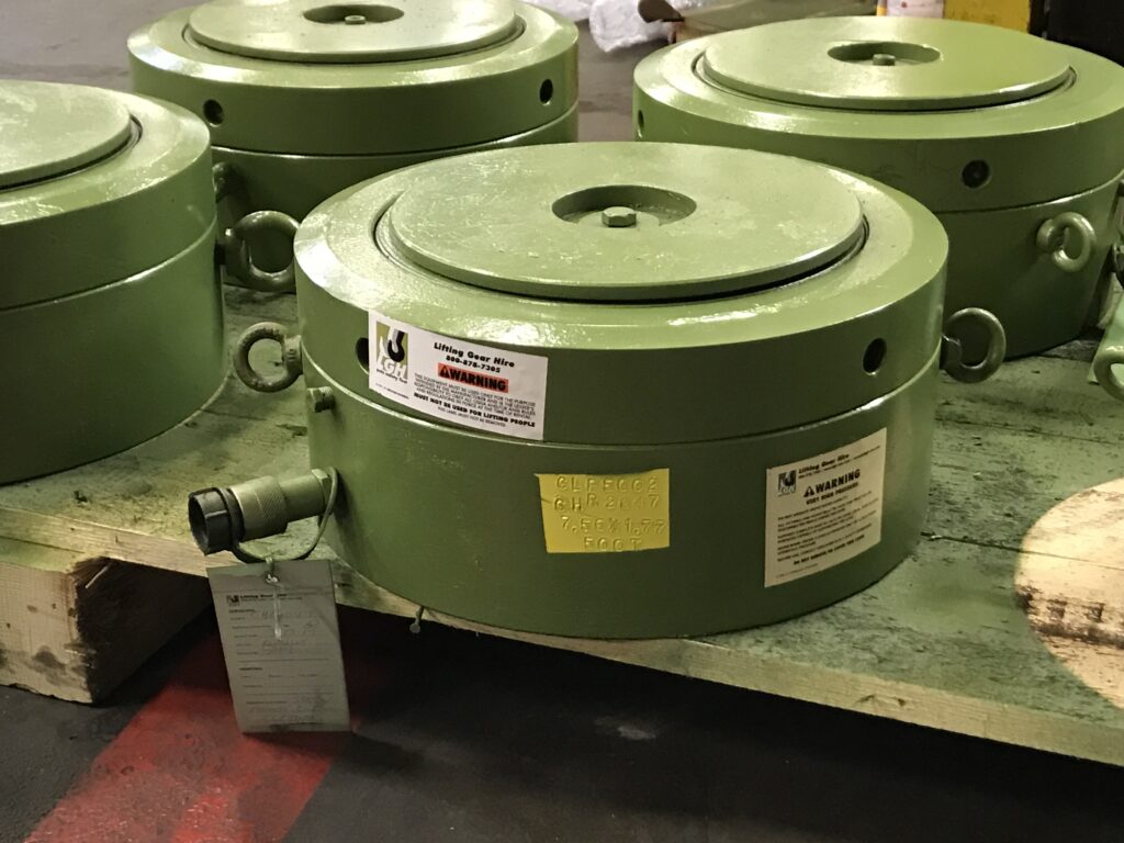 A photograph of multiple lock nut hydraulic cylinders inside of an LGH Rental Center.