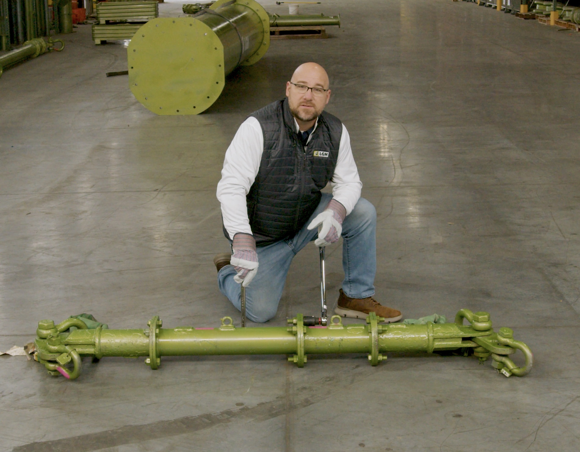 Screenshot of Aaron Orsak from LGH, demonstrating how to use a spreader bar in an educational video from LGH.