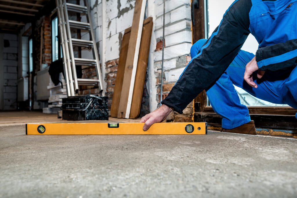 Professional worker measures the level of the concrete floor
