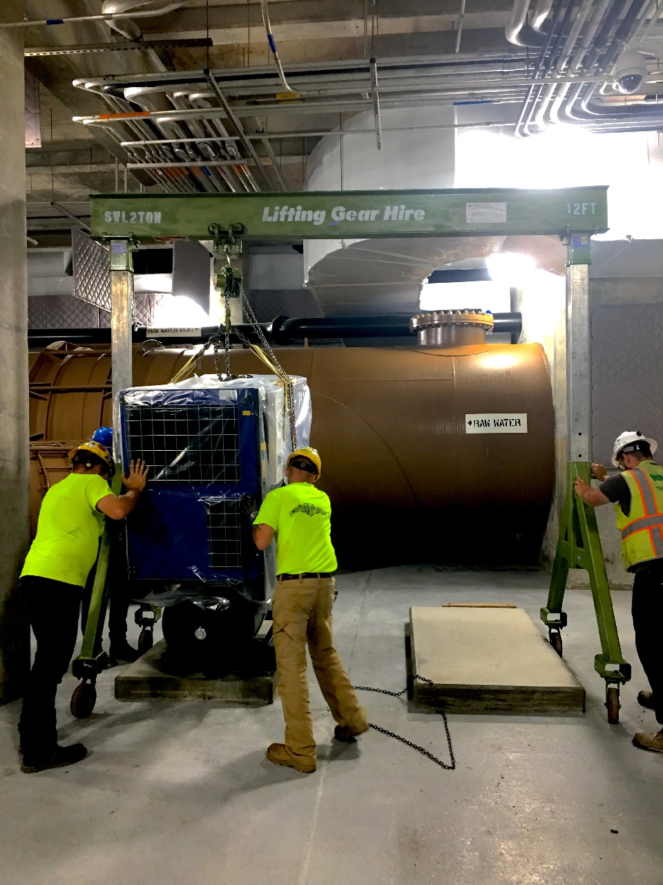 Construction workers on a jobsite, hoisting a load with an LGH Aluminum Gantry Crane rental.