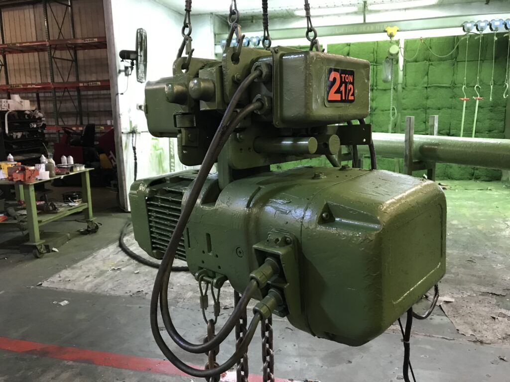 Product picture of a 2.5-ton Harrington SNERM electric chain hoist with motorized trolley rental from LGH, hanging inside of the LGH rental center.