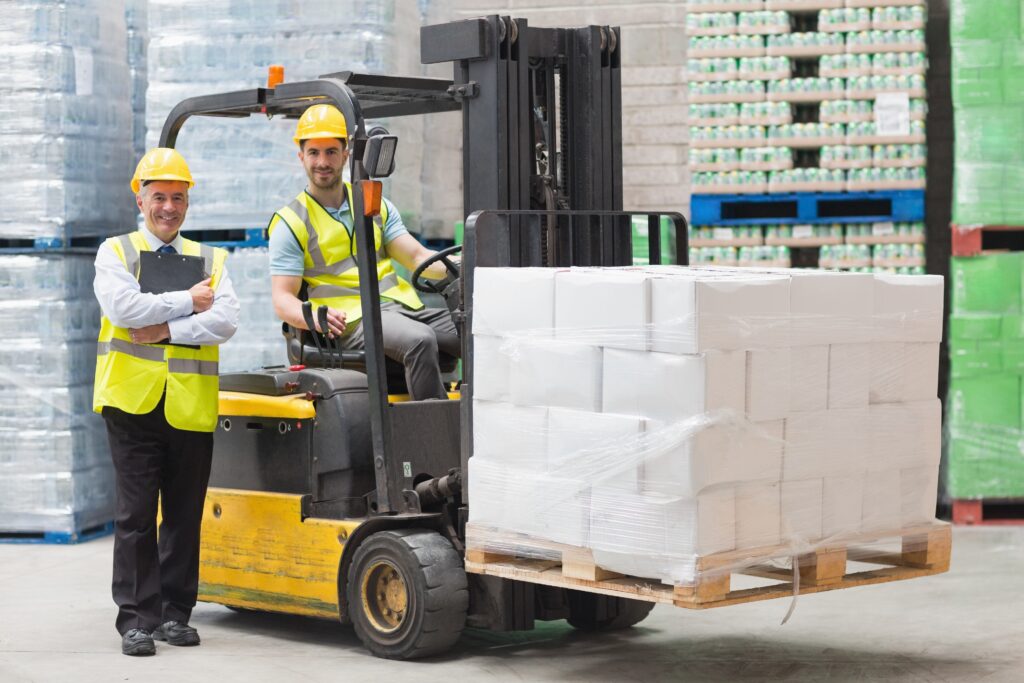 Stock photo of a Driver operating forklift machine next to his manager