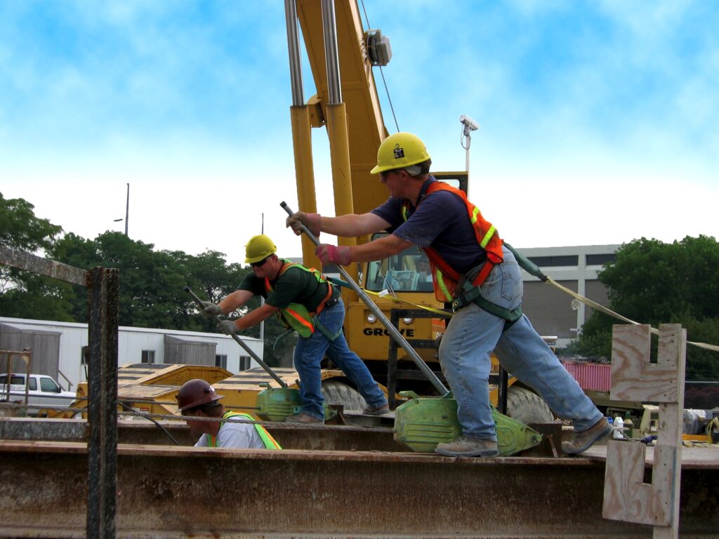 A jobsite photo of construction workers using a Tractel Tirfor rental from LGH, also commonly known as a Griphoist.