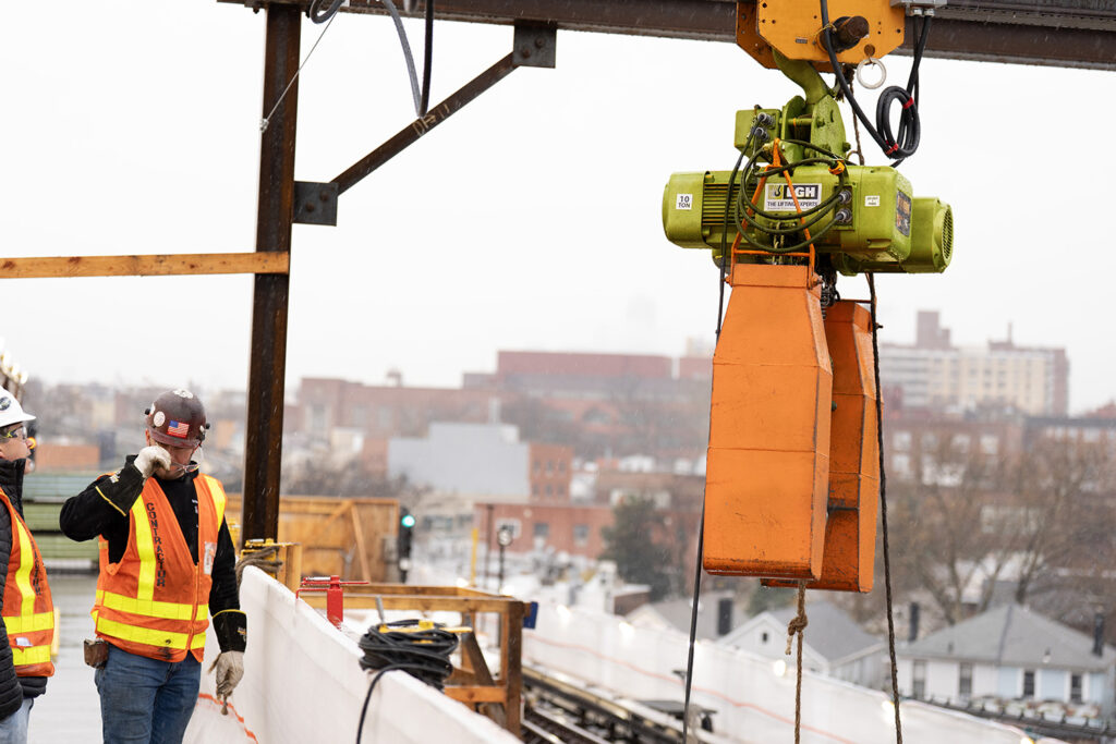 An electric chain hoist with chain bags on an active job in New York City, doing maintenance on the Metro train system.