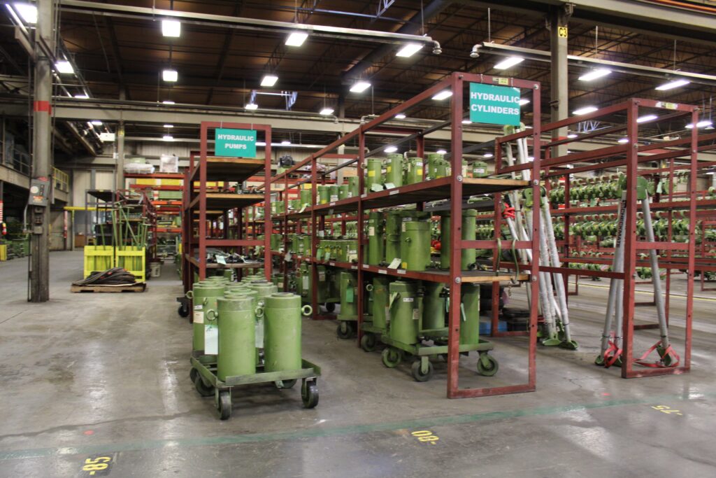 A photo inside an LGH rental center showing a vast array of hydraulic cylinders and pumps on shelves.
