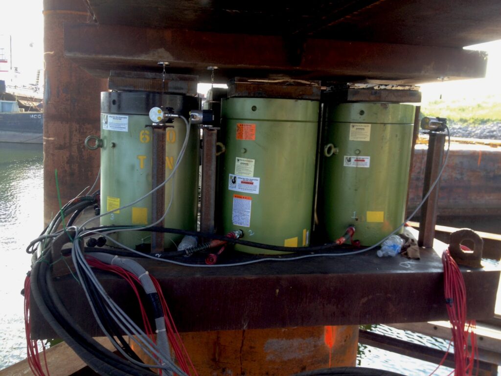 Jobsite photo of large heavy-duty hydraulic cylinders from LGH jacking up a bridge section.