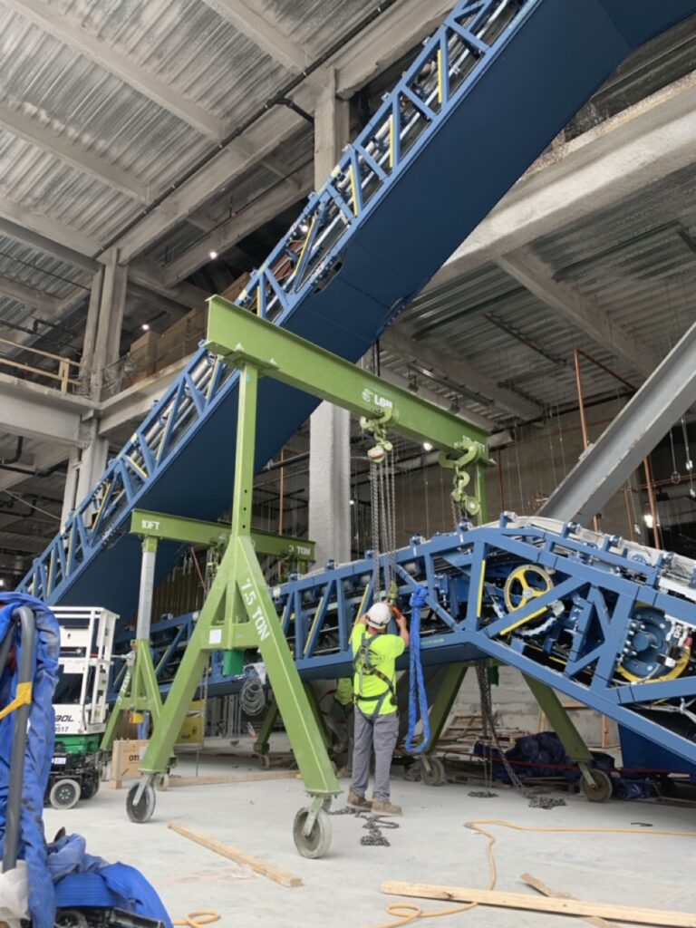2 LGH gantry cranes lifting an escalator on a jobsite with rigging