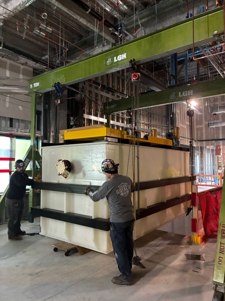 two 5 ton steel gantry cranes from LGH lifting a load on a jobsite
