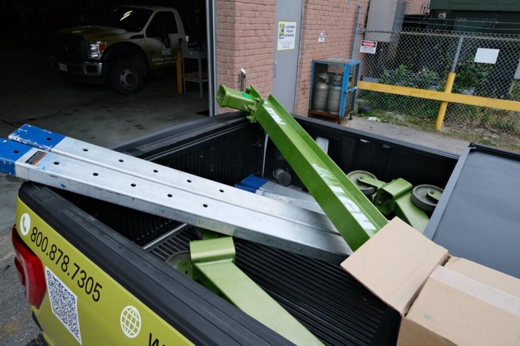 A disassembeled portable gantry crane rental from LGH, in the back of an LGH pickup truck.