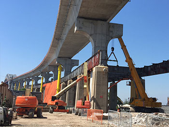 A crane lifting a section of a bridge using rigging and lifting equipment from LGH.