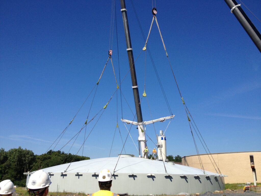 Wire rope slings and sheave blocks lifting a circular dome tank.