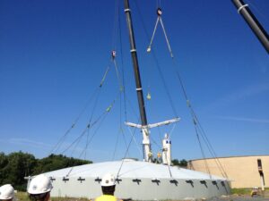 Wire rope slings and sheave blocks lifting a circular dome tank.